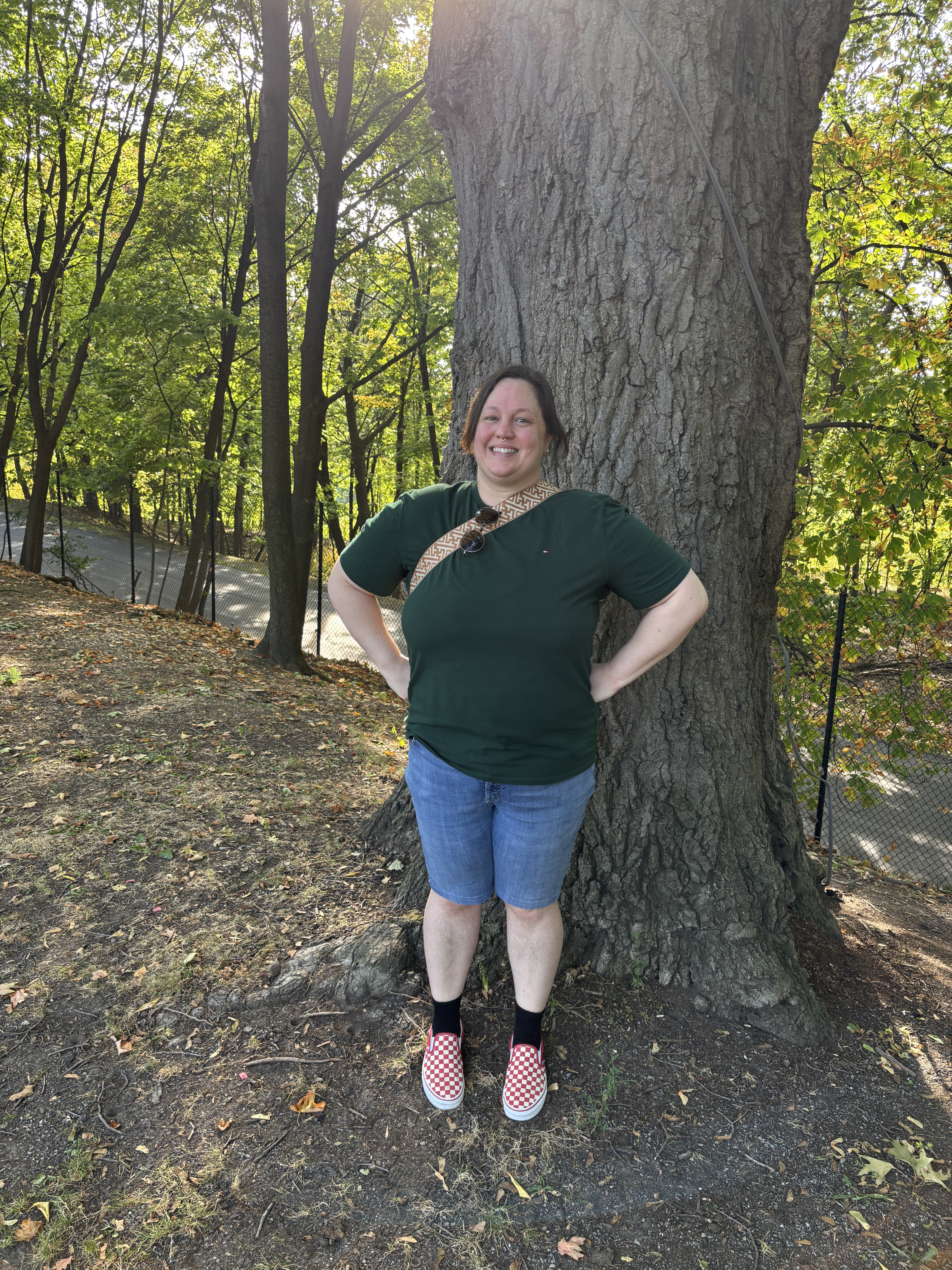 Finn doing a superhero pose in front of a tree
