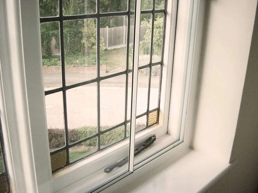 A picture of a white window with an adjustable secondary window glazing.