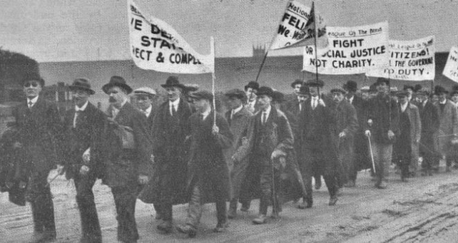 Blind people marching to Trafalgar Square. Banners read "Fight for social justice, not charity"