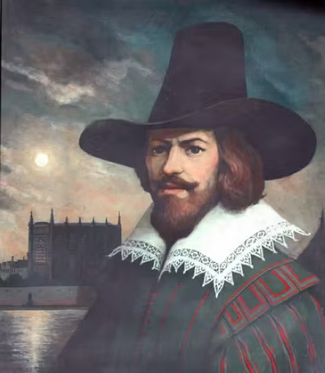 A painting of Guy Fawkes. A white man with long brown hair, mustache and beard wearing a large black hat and old fashioned clothing.