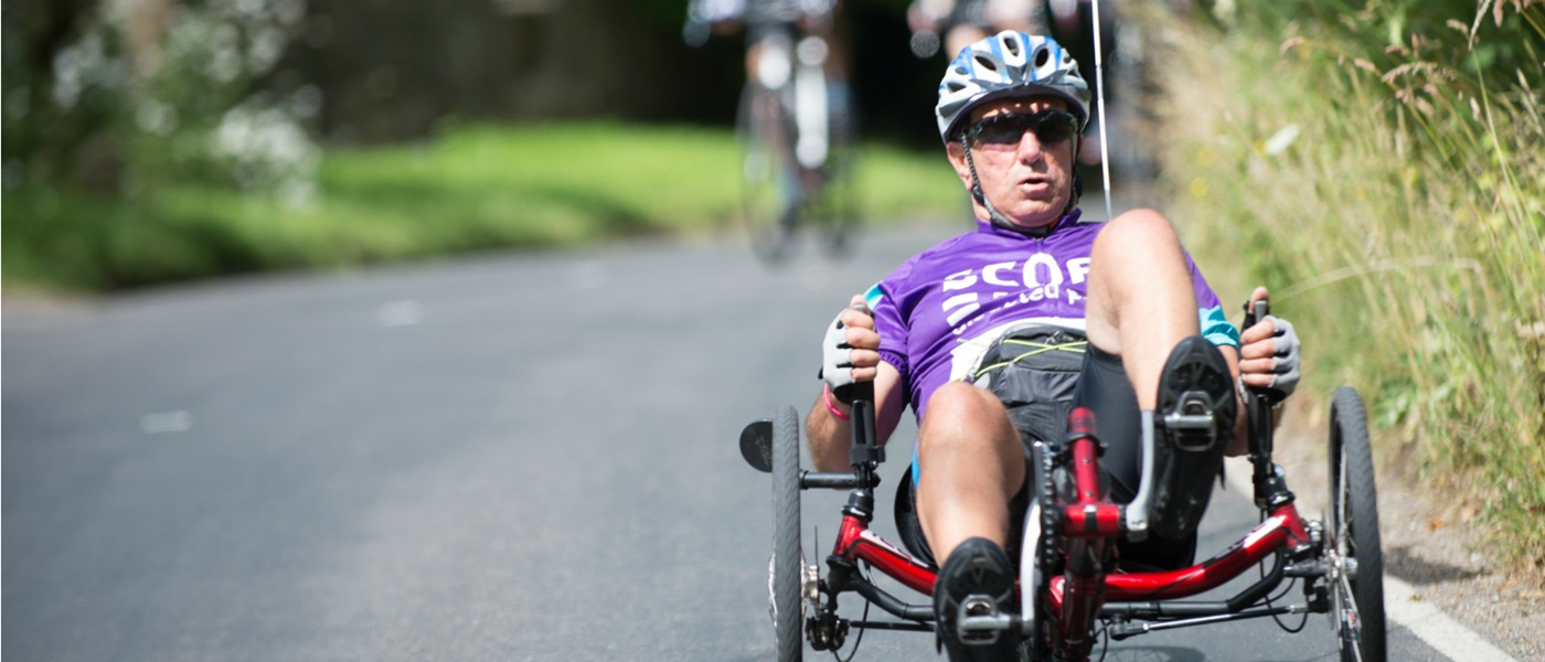 man wearing a scope t shirt using a recumbent cycle