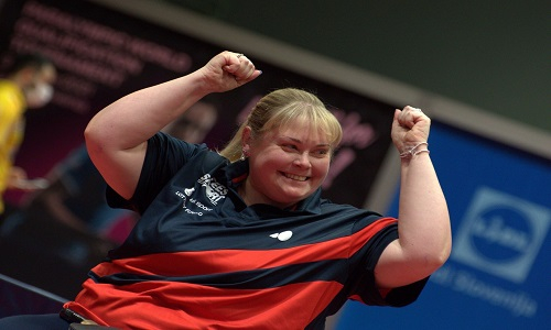 Sue smiling celebrating success with her arms raised