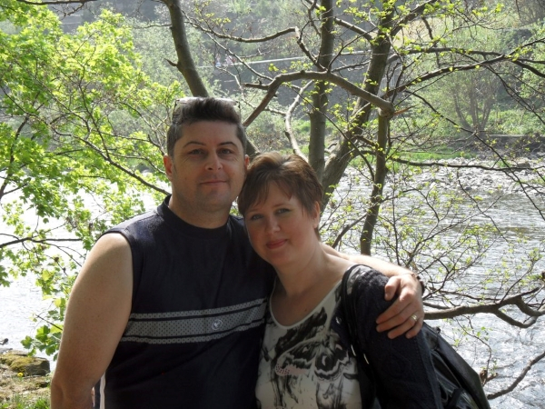 Victoria and her husband stood in woods