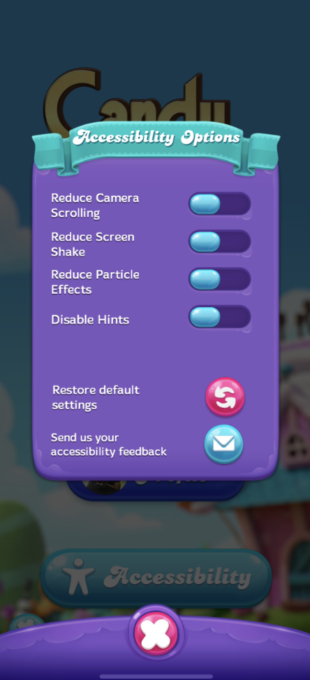 Accessibility options menu in 'Candy Crush Friends Saga' with toggles for reducing camera scrolling, screen shake, particle effects, and disabling hints, as well as buttons for restoring default settings and sending accessibility feedback.