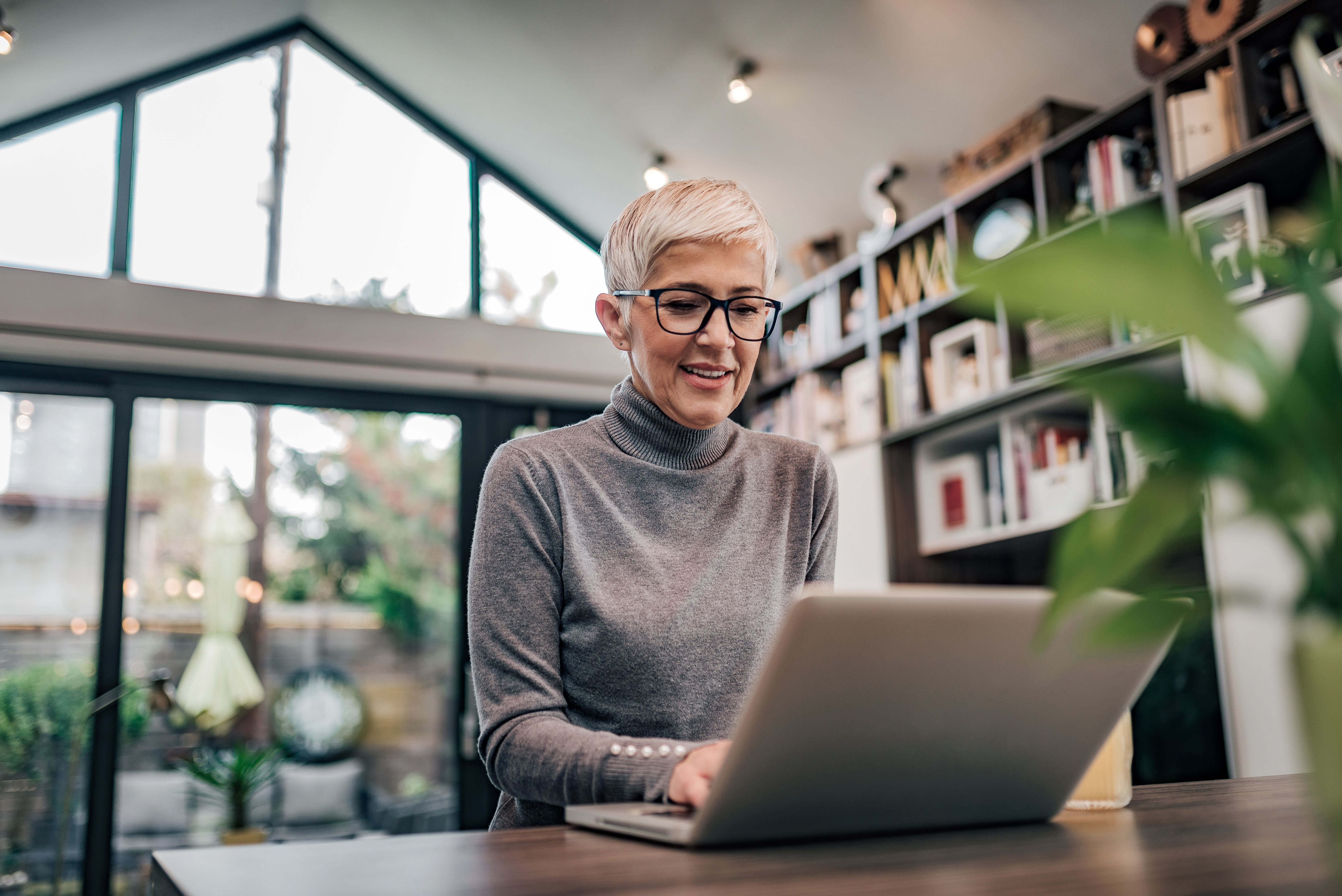 A woman smiling while she types on a laptop